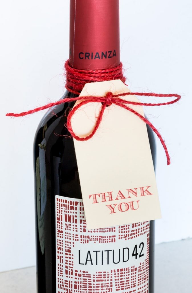 a bottle of wine with a free printable thank you gift tag tied on.
