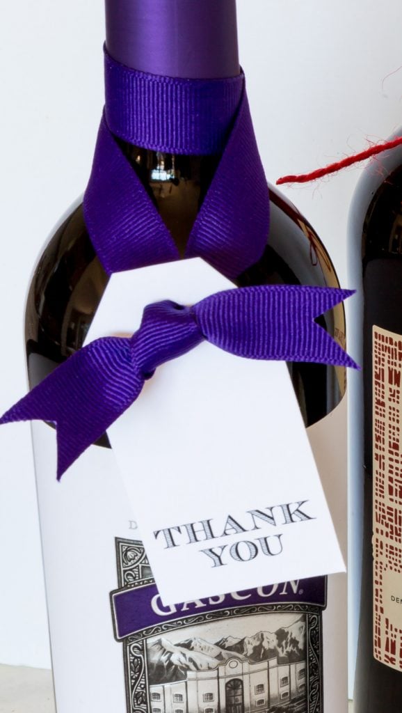 a bottle of wine with a free printable thank you gift tag tied on.