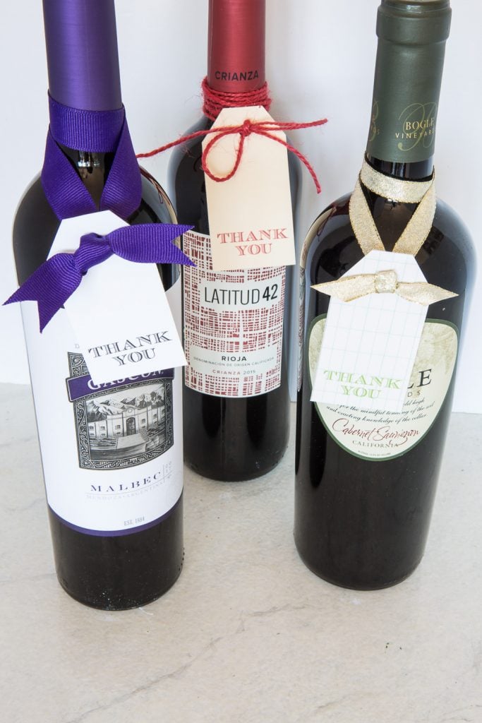 3 bottle of wine with free printable gift tags tied on to each one.