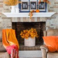Fall leaves in basket placed in an unused fireplace.