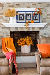 Fall leaves in basket placed in an unused fireplace.