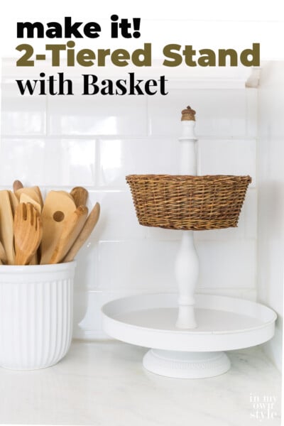 Newly made using parts from other items. White metal 2 tiered stand with a wicker basket and acorn final. text overlay says Make it! 2-Tiered Stand and Wicker Basket