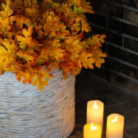 Cozy home interiors - basket in a fireplace filled with maple leaves.