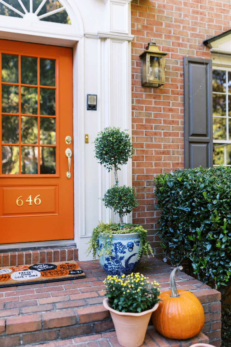 pretty orange front door on a brick house