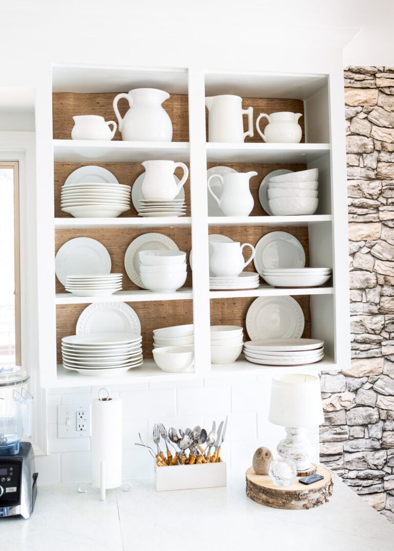 Open shelves in kitchen with wallpaper added to the back of each shelf to add contrast and interest.