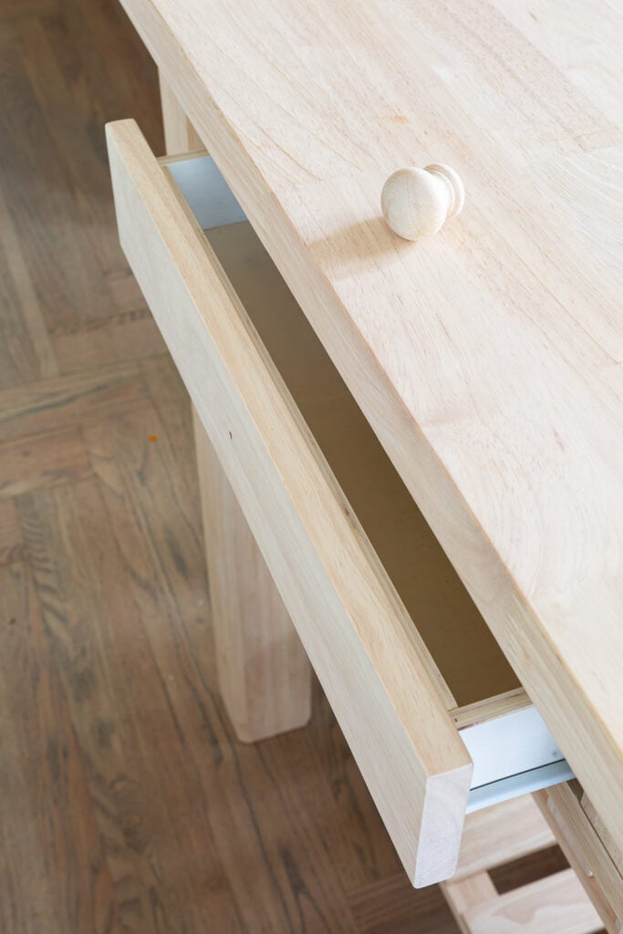 close up of wood drawer in wood kitchen island before getting painted with Sherwin Williams Emerald paint.
