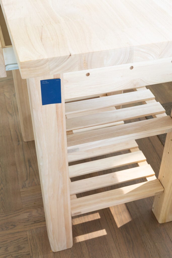 looking down at the two slatted wood shelves on wood kitchen island before getting painted with Sherwin Williams 9176 Dress Blues paint.