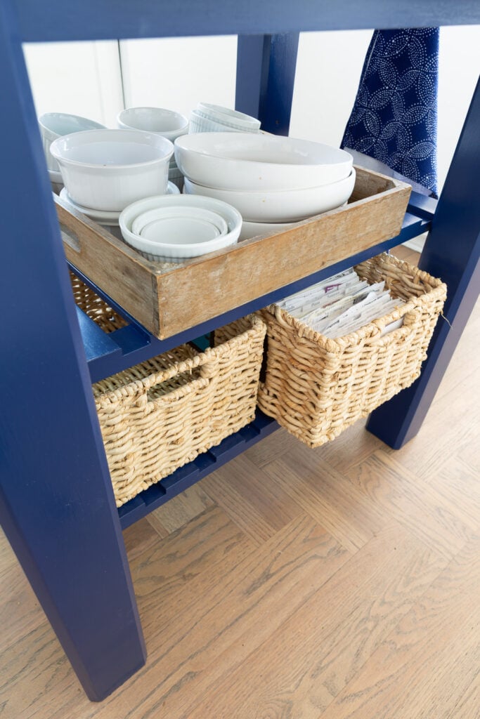 Close up of painted kitchen work table island with two shelves and what you can store on them.