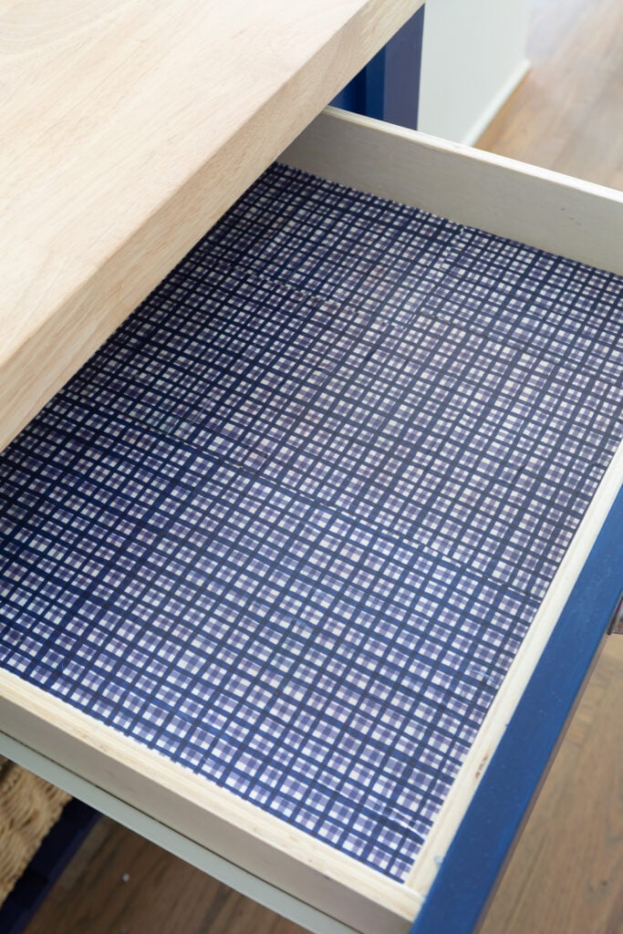 Lining a kitchen drawer with decorative paper and sealing with matte sealer.