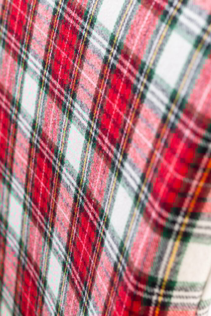 close up of the red and white Christmas plaid fabric used to cover dining table chairs for the holidays.