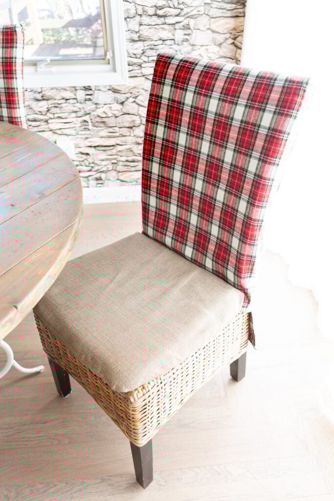 a Christmas fabric covered dining chair pulled back away from the dining table.