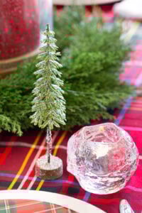 Cute glittered pine tree decoration from Hobby Lobby on table setting along with a Kosta Boda snowball votive holder.