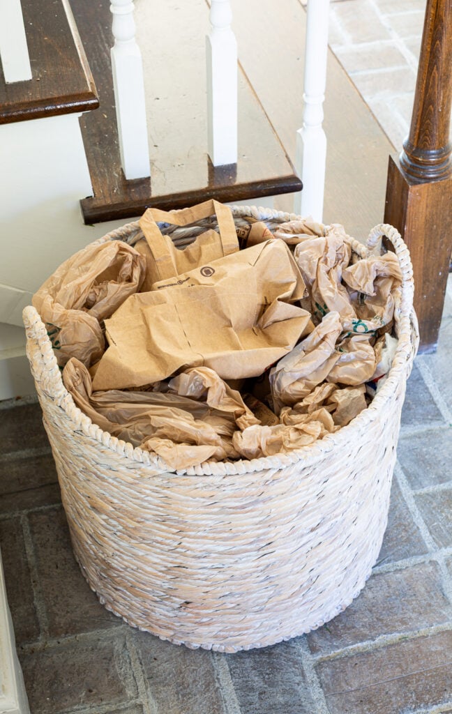 rumpled brown paper bags filling up a large woven floor basket.