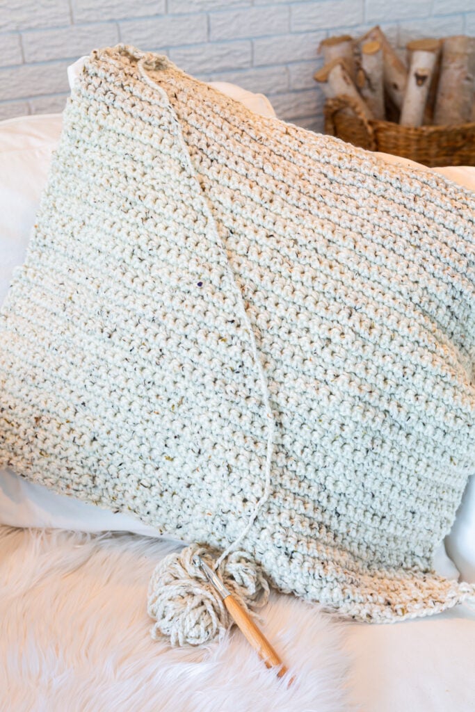 Fitting a crochet piece to the front of a throw pillow.