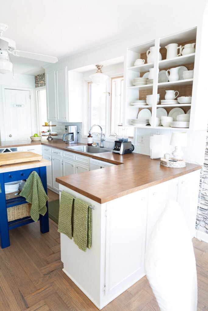 Looking at another view of the sink area in kitchen with white cabinets and brown Formica counters