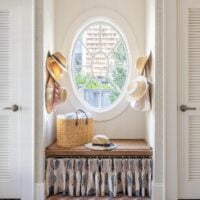 a oval window flanked by two closets in a beach house.