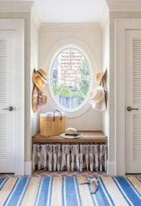 a oval window flanked by two closets in a beach house.