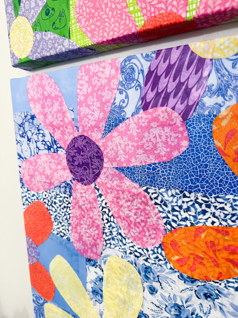 close up of colorful fabric flowers Mod Podged on a repurposed canvas