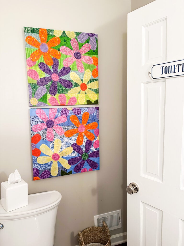Two repurposed artist's canvases covered in cut out fabric flowers.