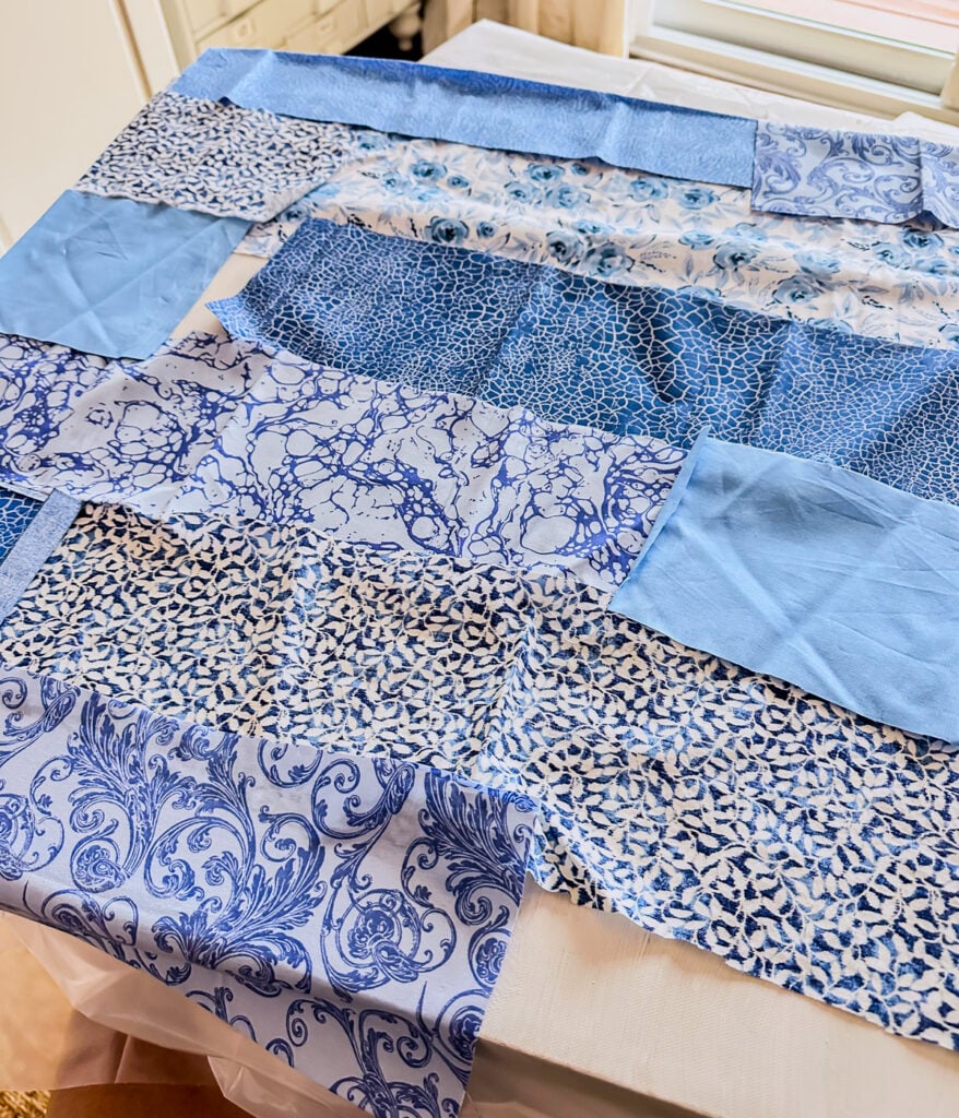 Cut out fabric strips being attached to a white painted canvas with Mod Podge.