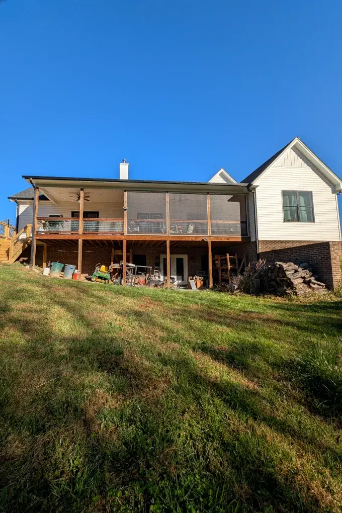 Back side of our house with a deck and equipment underneath the deck