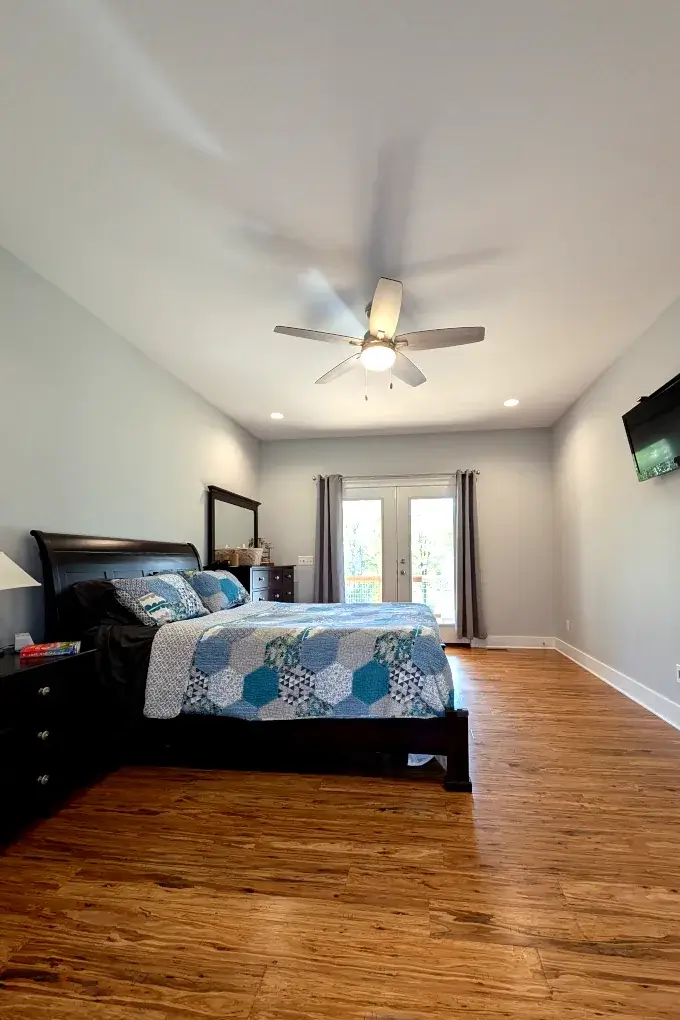 Bedroom with a bed and French doors in the background