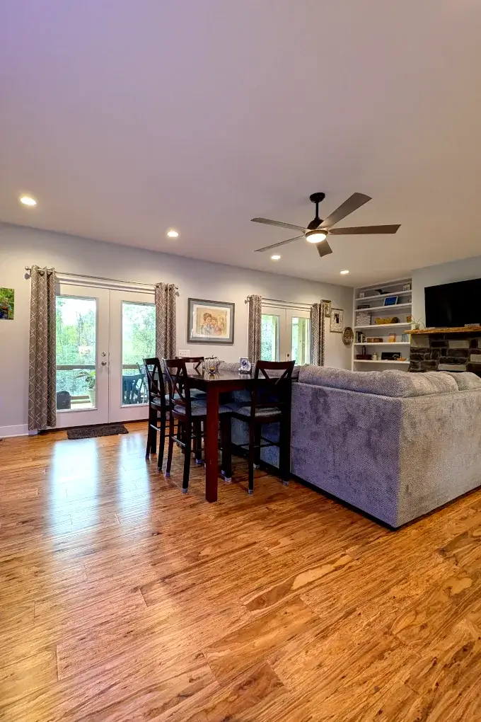 Open room with a dining table next to a gray couch