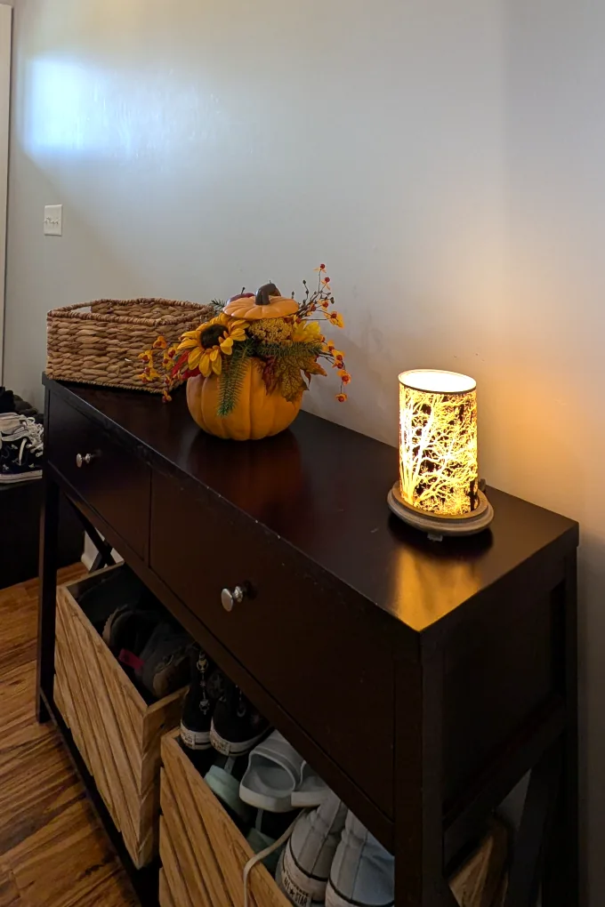 Entry console with a basket, a wax warmer, and fall decor