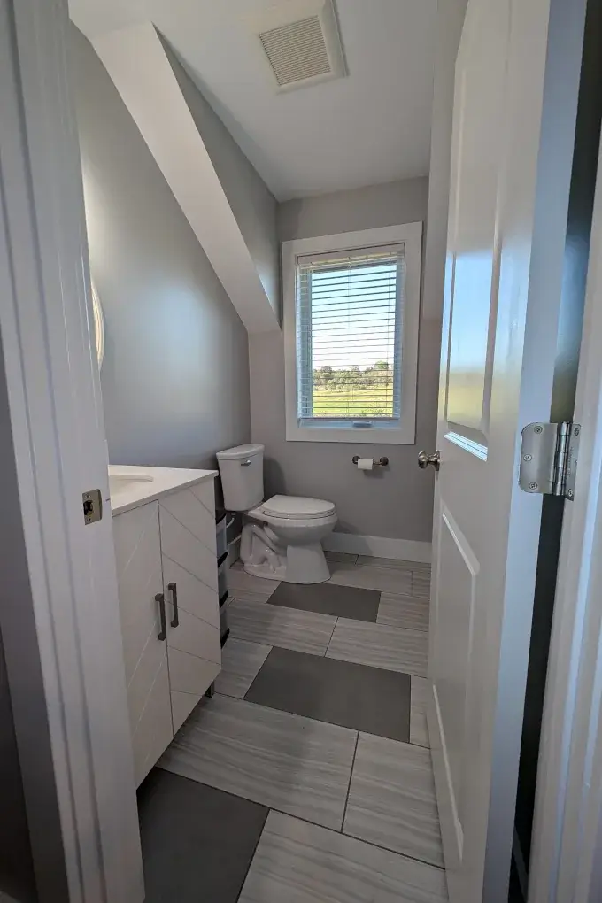 Bathroom with a white cabinet and gray tiles