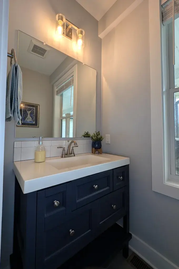 Blue bathroom vanity with mirror and white countertop
