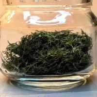 Dried dill in a glass jar with text "4 different ways to dry dill weed"