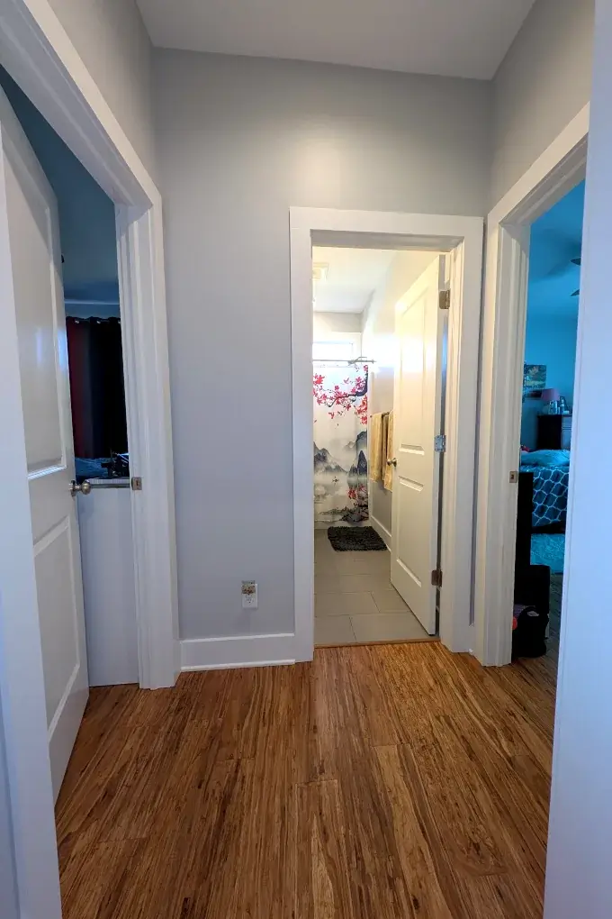 Small hallway with bathroom in center and two bedrooms on each side