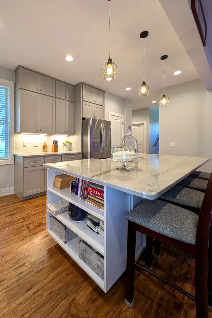 Kitchen cabinets with an open bookshelf on the end of the island
