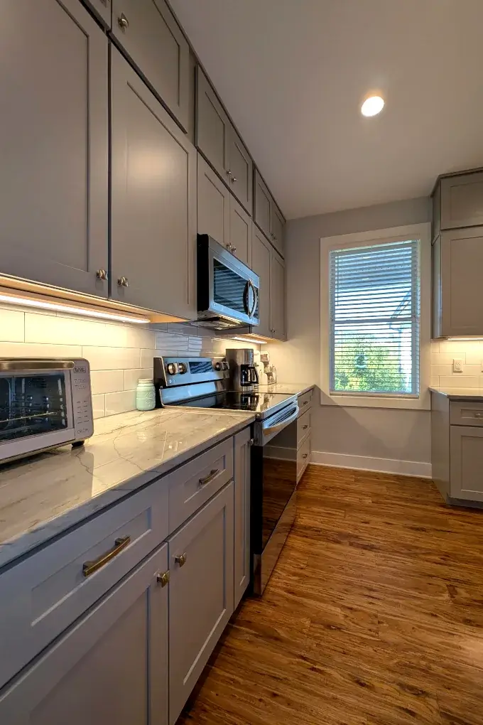 Upper and lower cabinets with white subway tile and gray grout between them