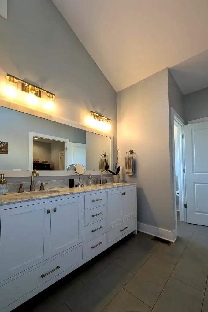 Bathroom with white vanity with two sinks and a mirror above
